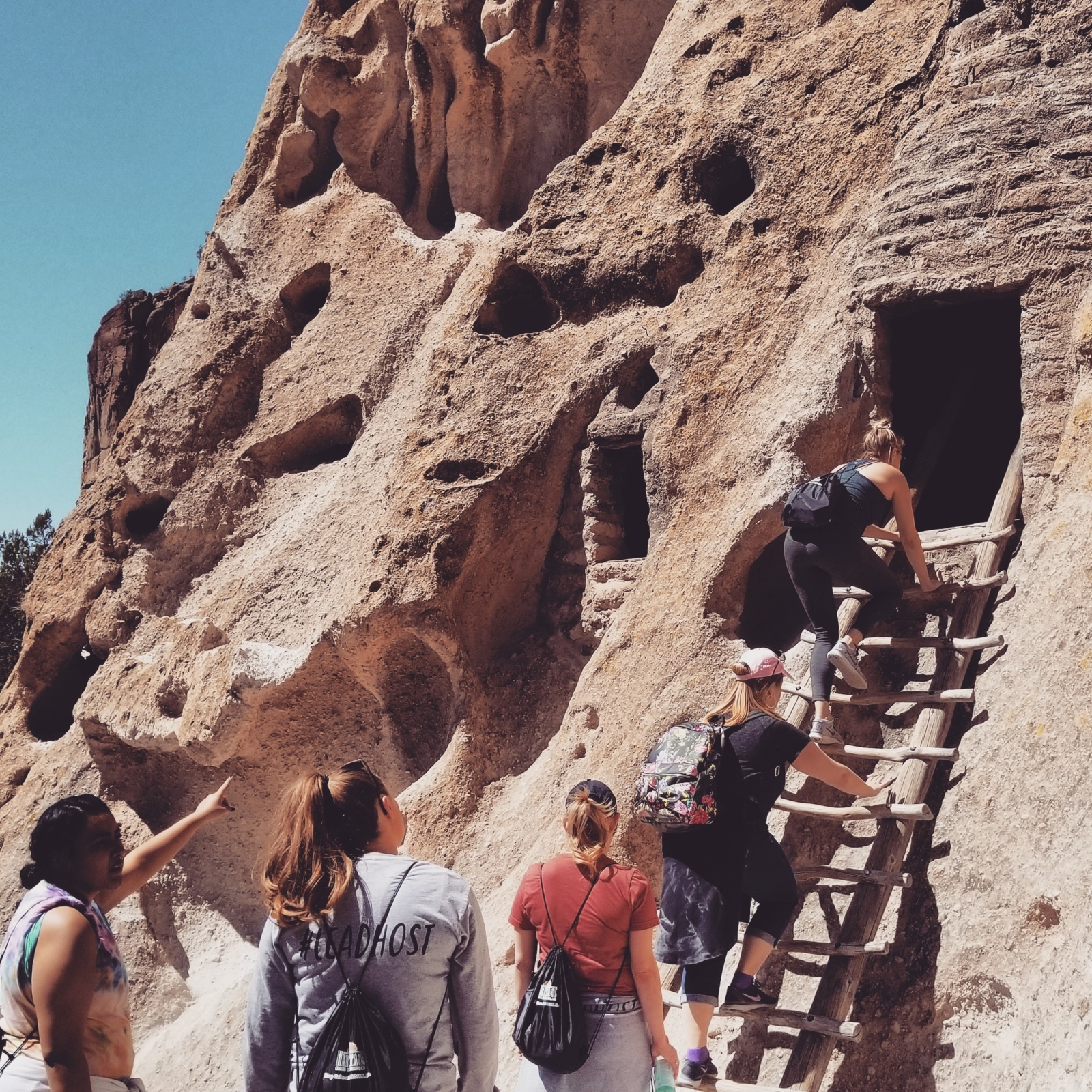 Guests climb up the ancient ladders at Bandelier National Monument outside of Santa Fe, New Mexico.