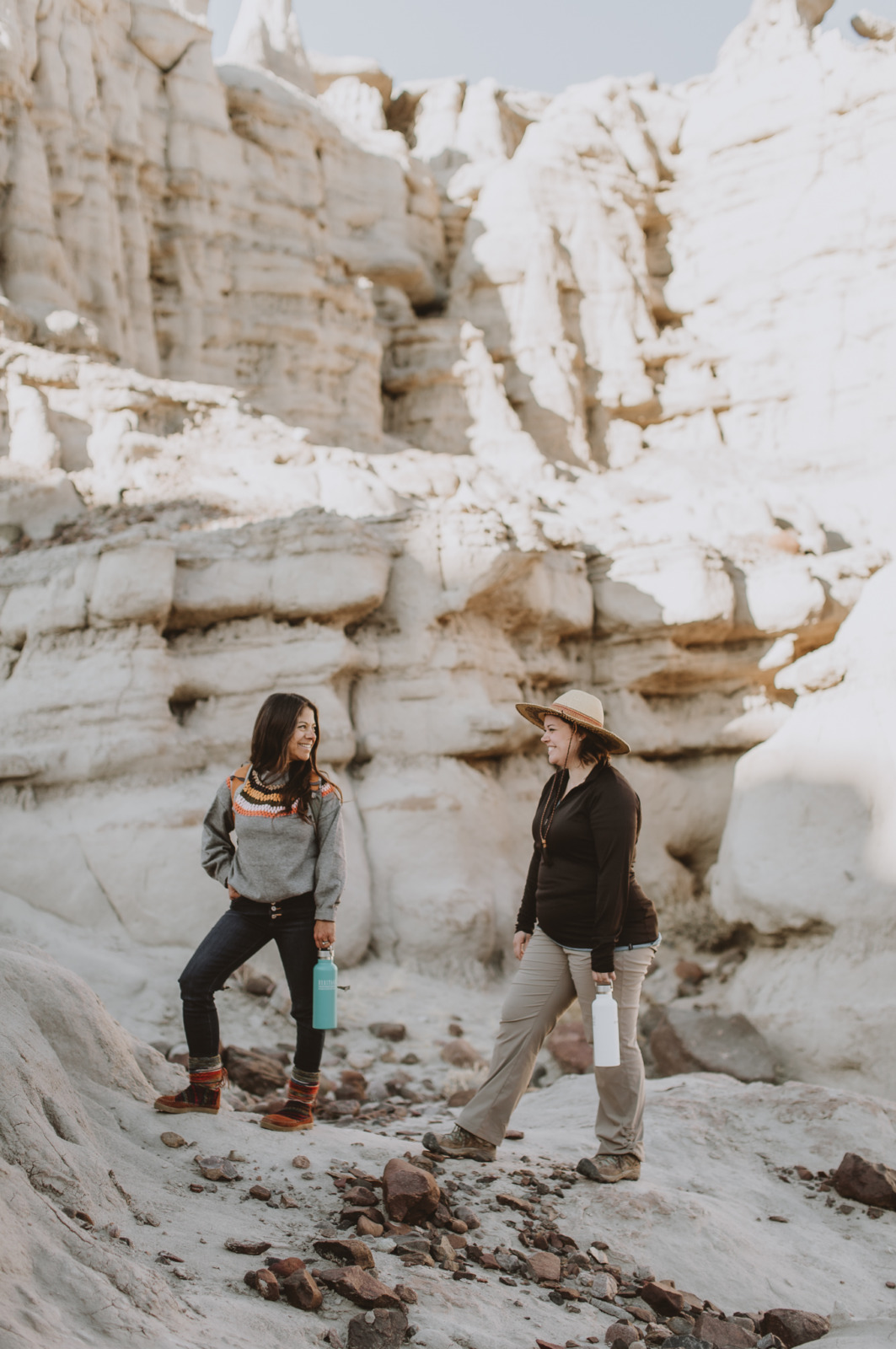 Two hikers shown in Plaza Blanca, New Mexico's white sandstone rock.