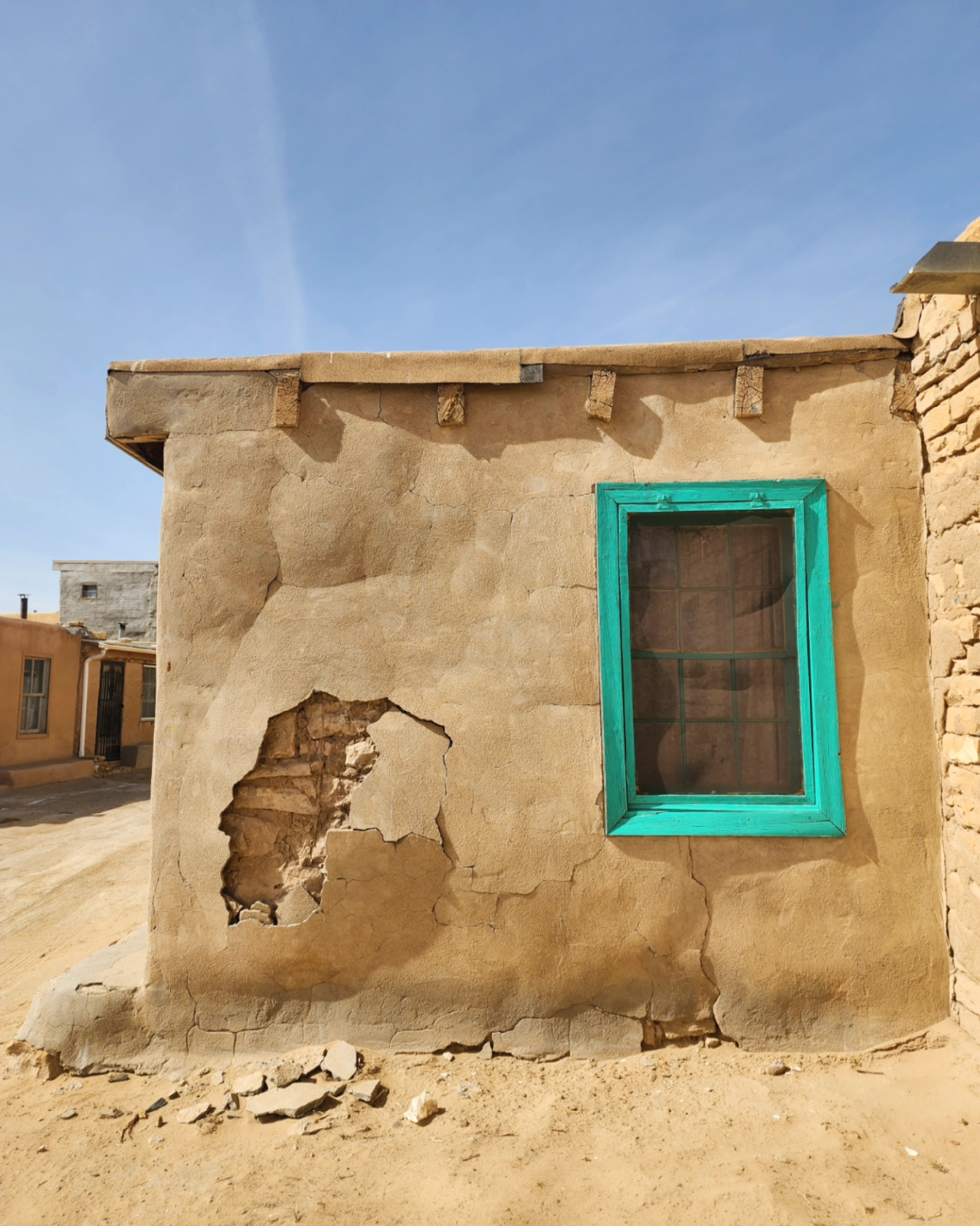 Turquoise window frame on an adobe brick building in Acoma Pueblo.